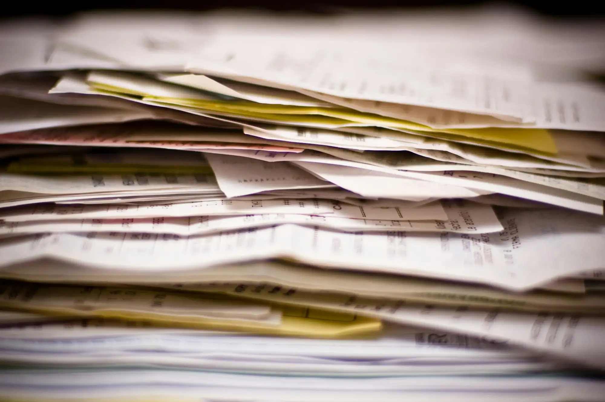 Factures et documents imprimés empilés, vus de côté.