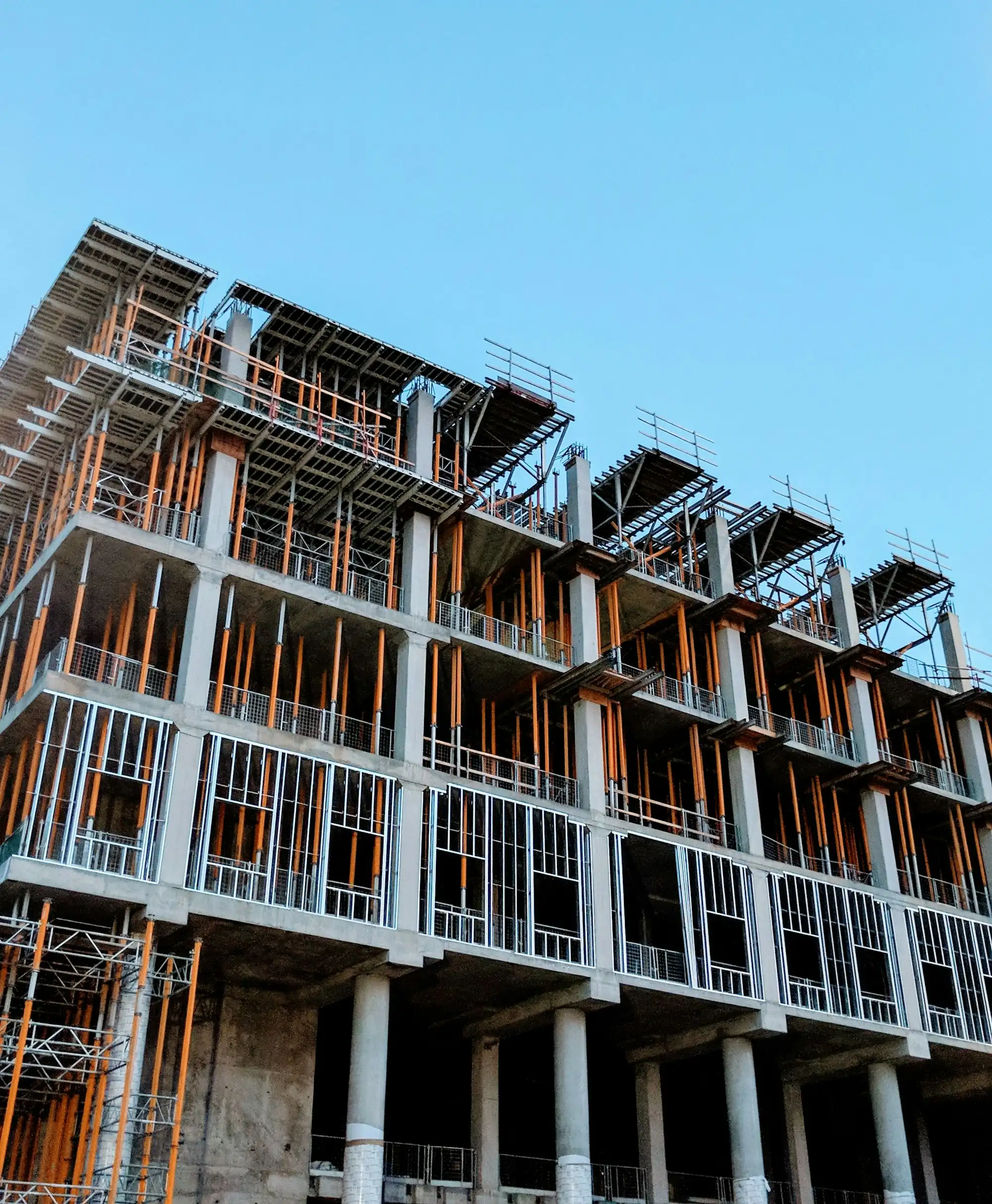 Immeuble en construction, structure en béton avec étais et ossatures métalliques en façade.